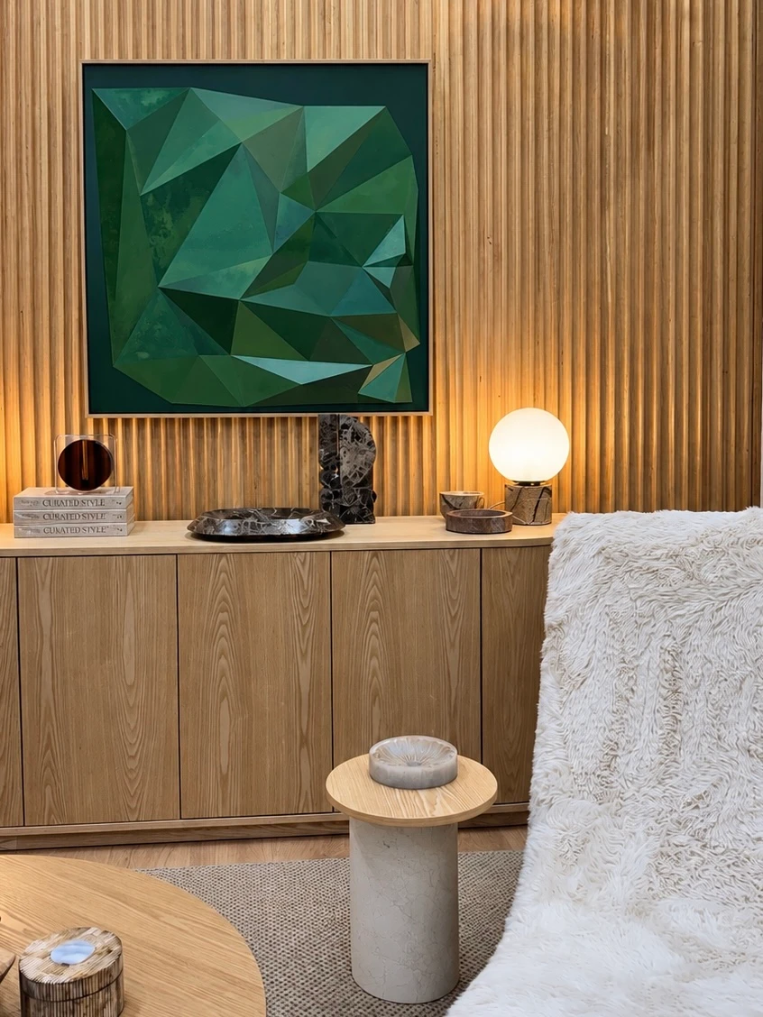 Green geometric relief displayed against a timber wall in an interior