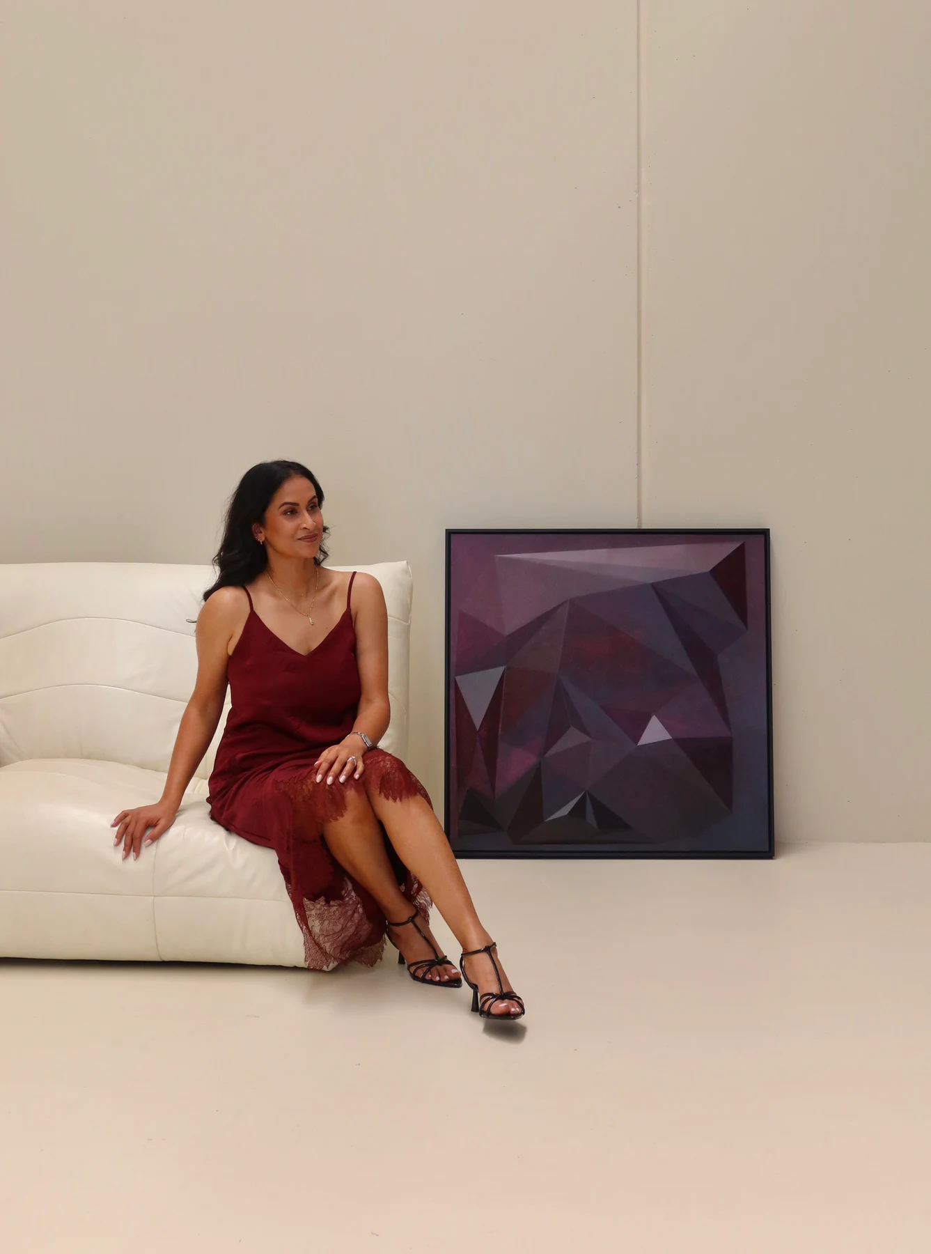 Artist seated on a white sofa beside Within Colour