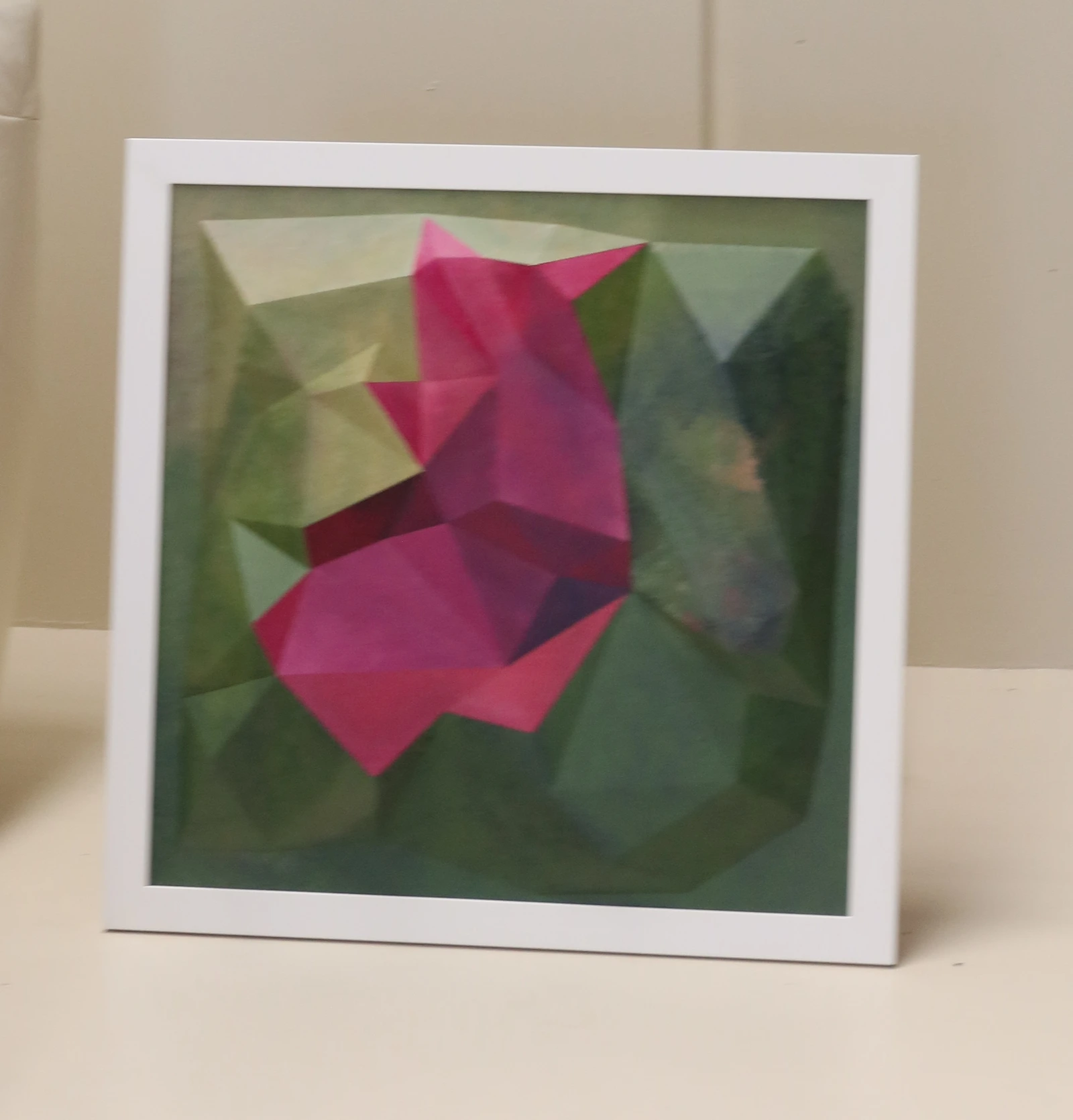 Still Becoming in its white frame beside a white sofa